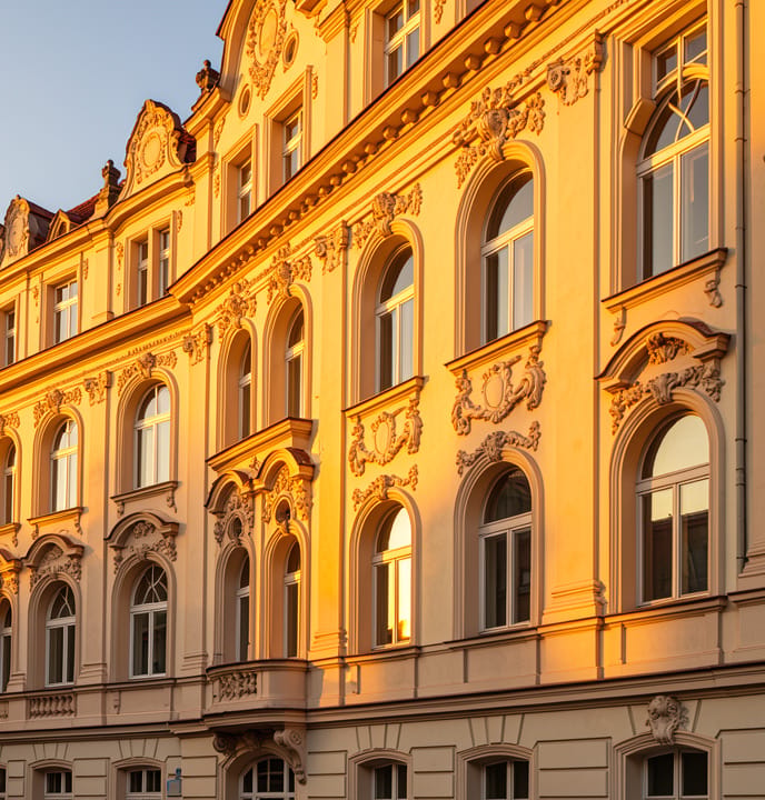 Klassische Berliner Altbau-Fassade mit Stuckverzierungen im warmen Abendlicht