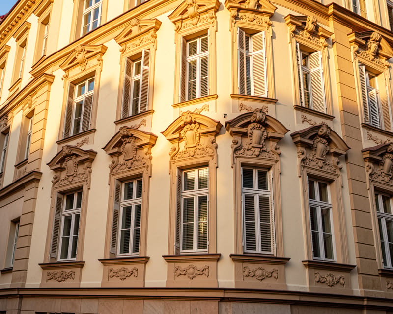 Berliner Altbau-Fassade mit ornamentalem Stuck und hohen Fenstern im warmen Abendlicht